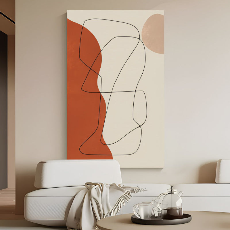 Abstract art piece on a wall above a white sofa in a living room.